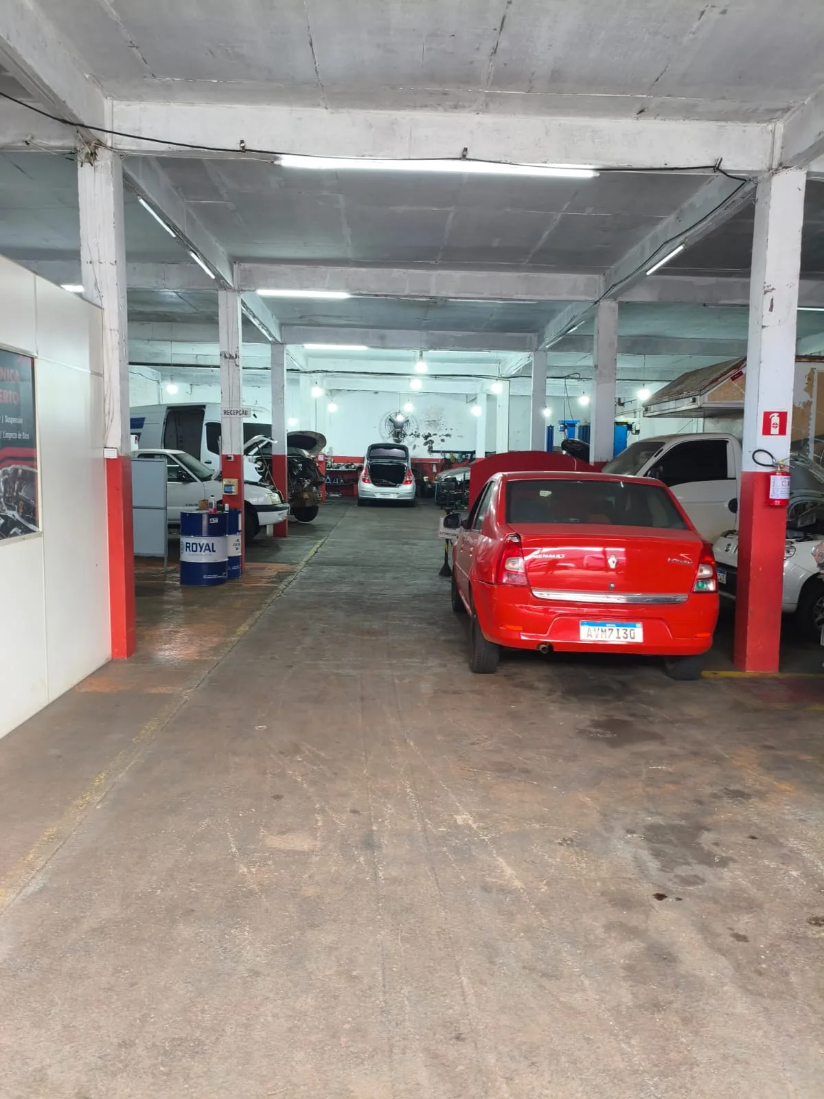 Corredor da oficina com carros em serviço e a recepção ao lado