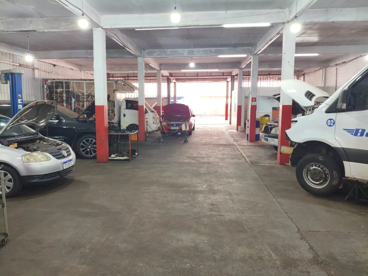 Salão da oficina com elevadores e carros em revisão